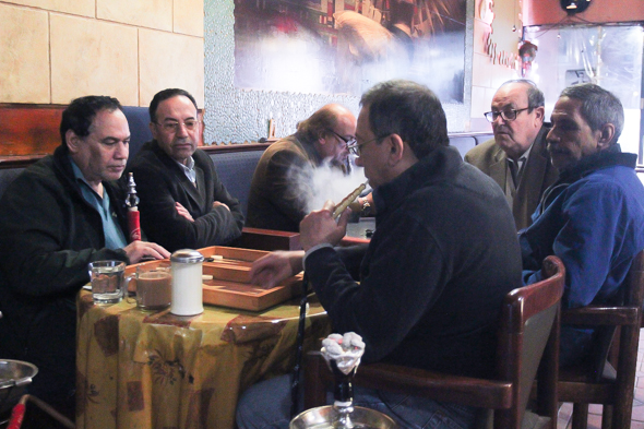 Labib Salama smokes hookah and plays backgammon with regular customers at the Egyptian Coffee Shop. Photo: Esha Mahajan.