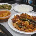 (Clockwise from front) Chicken devil, chicken curry, beans with onions, and white rice are always available on Sundays at New Asha Sri Lankan Restaurant. Photo: Amanda Burrill