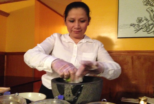  One of Mexico 2000's three waitresses, Martha Morales, squirts lime juice into the restaurant's spicy guacamole. Photo: Lisa Spear