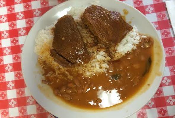 Two pieces of stewed beef, on top of rice and beans from Margot's restaurant in Washington Heights.