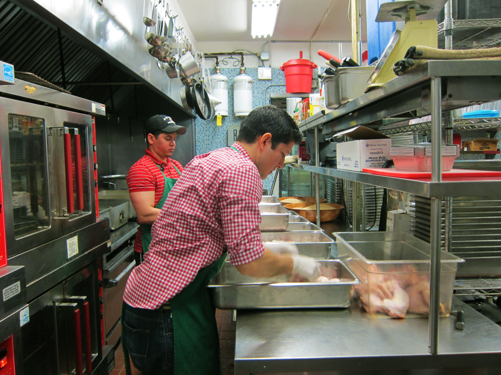 Ruben with Alex, the kitchen helper, cooking chicken for the recipients. Photo: Gema Flores