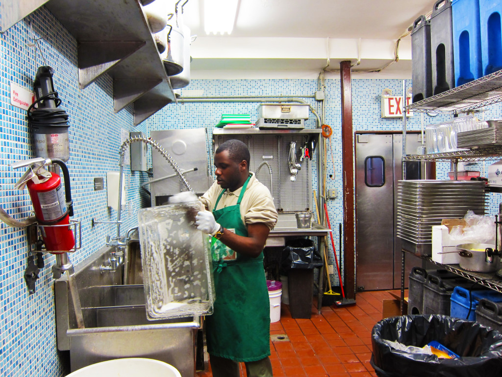 One of the volunteers at Masbia cleaning the kitchen. Photo: Gema Flores
