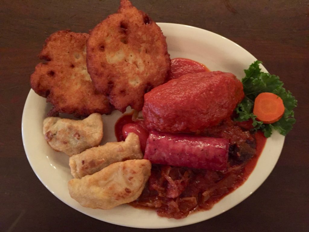 The plate of Polish specialties – three pierogis, two potato pancakes, polish kielbasa, hunter’s stew and stuffed cabbage.